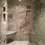 Custom shower with modern fixtures and granite seating